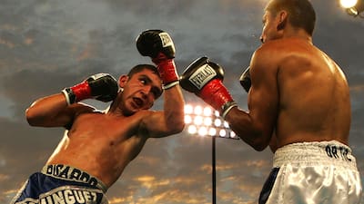 Two boxers go at it under the bright lights
